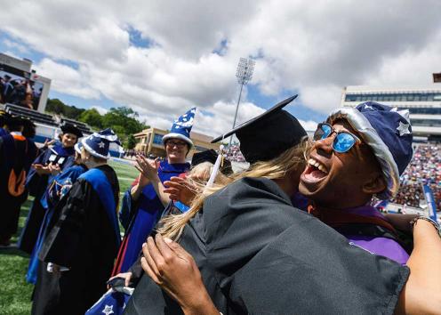 Graduates in wizard hats hugging